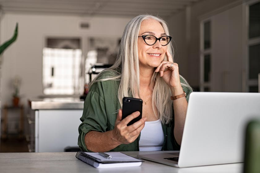 grey haired woman working on laptop