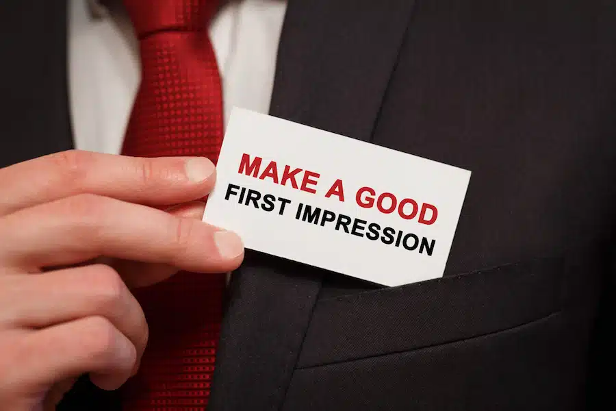 Businessman putting a card with text Make a good first impression in the pocket