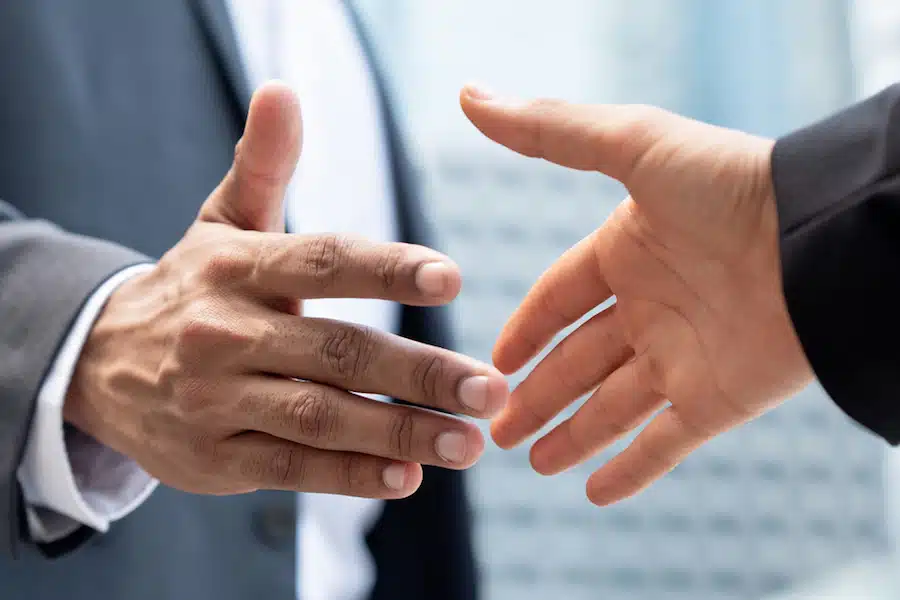 Banner image of businessman hands making handshake in the city for merger and acquisition concept