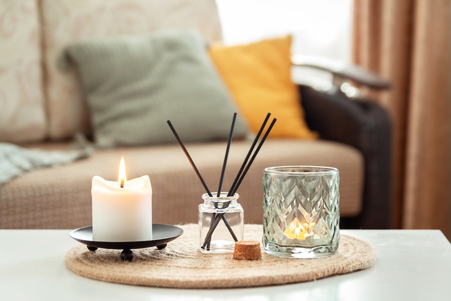 Scented candles and aroma incense sticks on table in living room of an event venue. Aromatherapy, home fragrance. Concept of home relaxation and anti stress