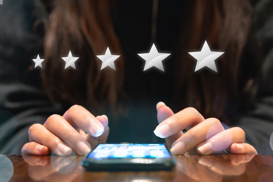 Woman filling out 5 star silver customer service feedback survey by email on smartphone device after hotel guest experience - Company satisfaction rating, retention and quality of service concepts