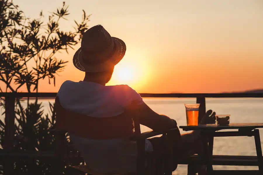 Young man enjoying sunset at a beach bar