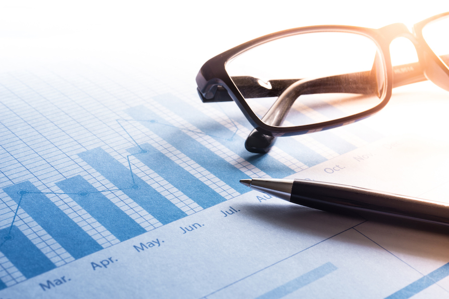 Pen and glasses on business graph chart.For business and financial,investment concept.