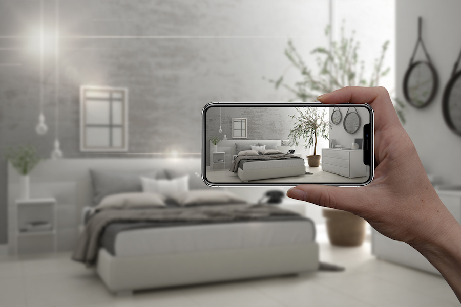 Hand holding smart phone, AR application, simulate furniture and interior design products in real home, architect designer concept, blur background, modern bedroom