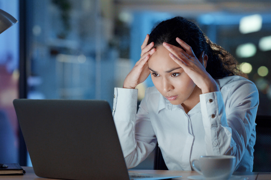 Frustrated, stressed and worried businesswoman worker expressing disappointment reading bad news on her office desk. Overwhelmed, concerned and irritated female employee upset over a mistake.