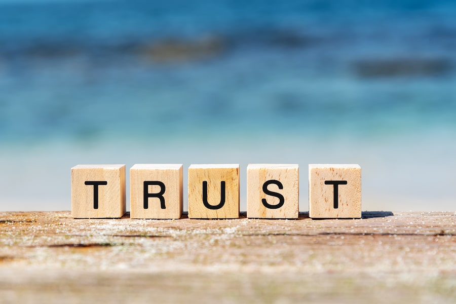 "Trust" text on wooden block at the beach