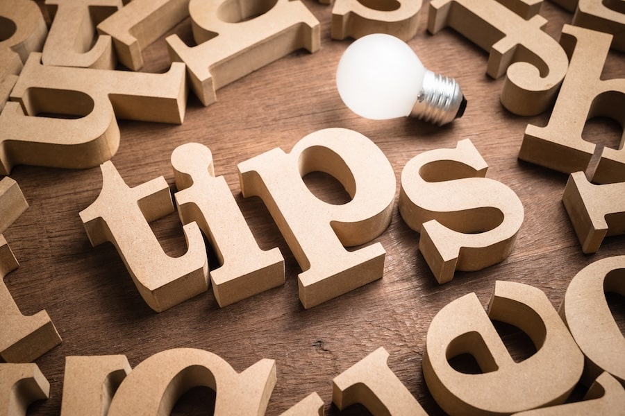 "Tips" wooden word in scattered wood letters with glowing light bulb