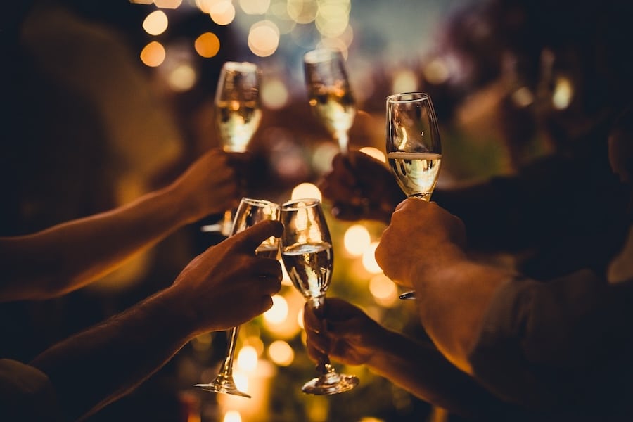 Numerous hands holding champagne flutes with champagne celebratory toast silhouettes