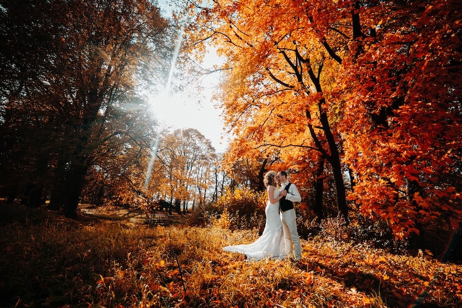 beautiful bride and groom walking in the autumn lawn